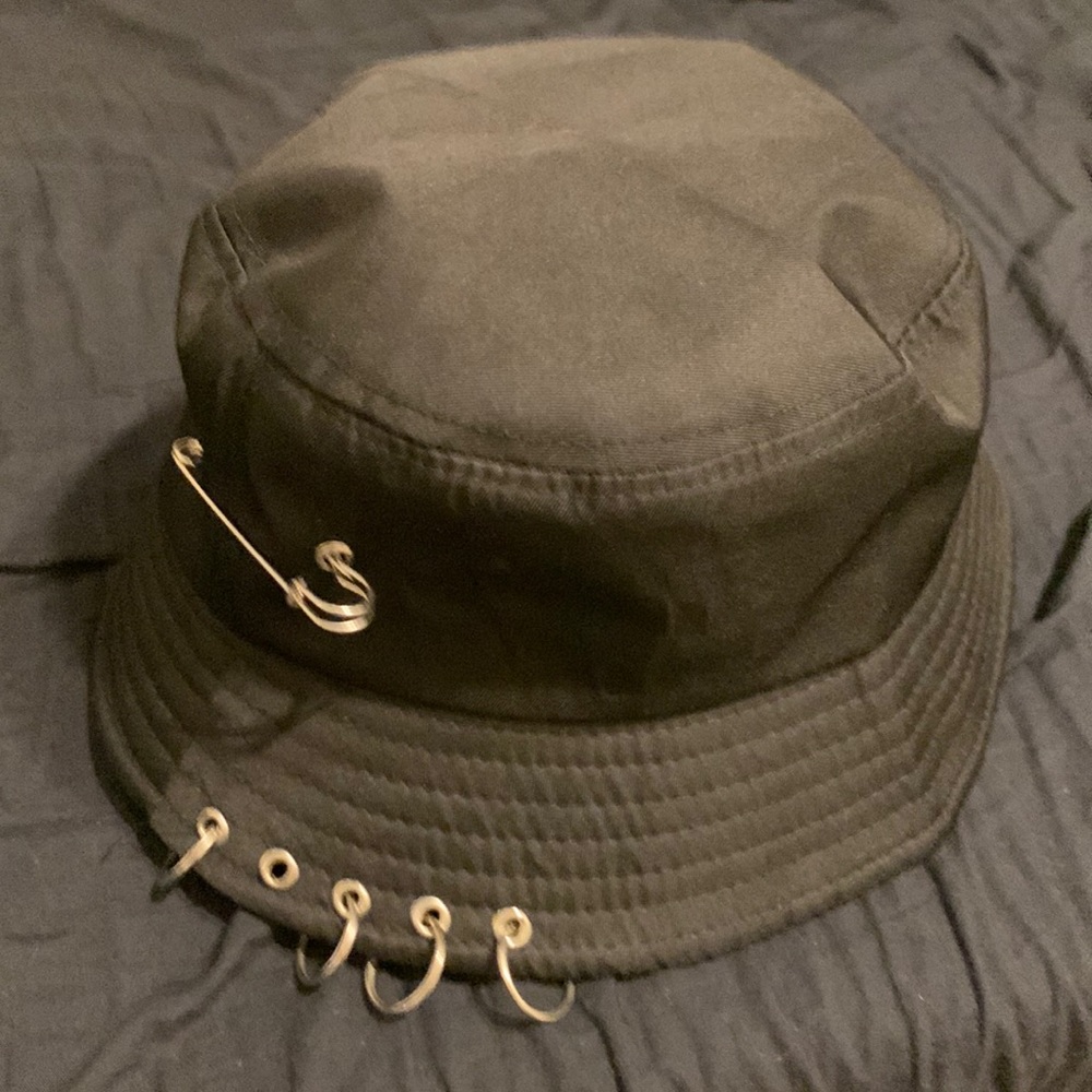 Black bucket hat with multiple accessories on top